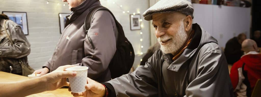 en gäst får en mugg med kaffe på ny gemenskap gåvobrev aktier